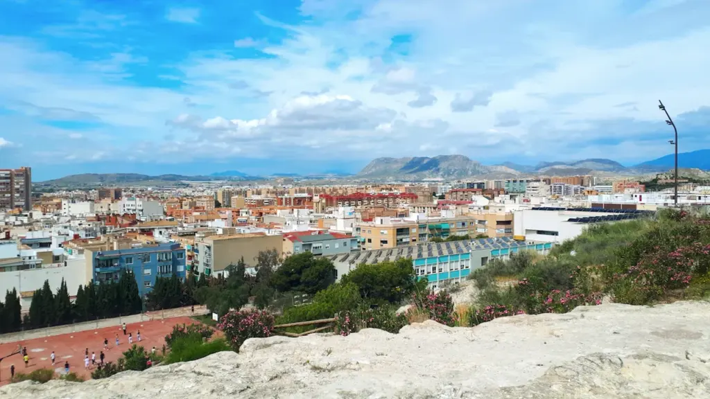 Vista panorámica del Parc del Tossal sobre la ciudad de Alicante con montañas