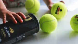 Pelotas de tenis oficiales del US Open sobre una mesa blanca.
