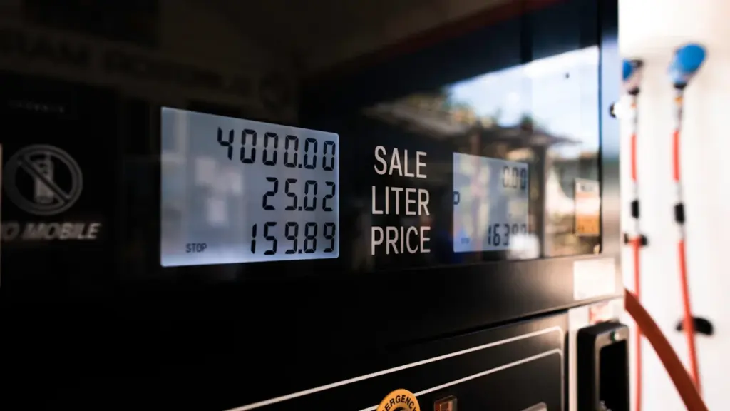 Primer plano de un surtidor de gasolina digital mostrando precios de combustible.