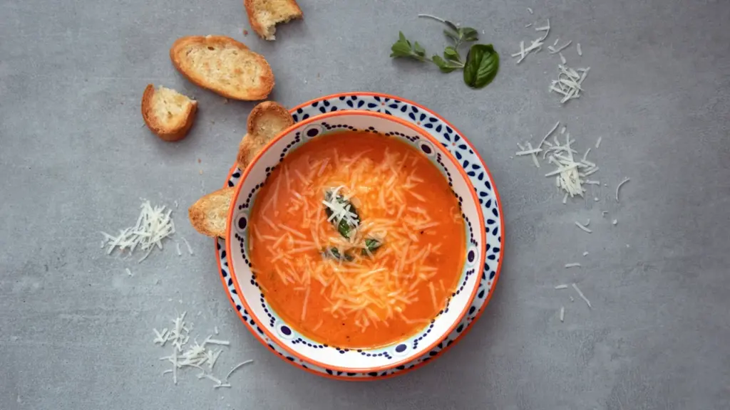 Un plato de salmorejo cordobés con guarnición servido en un cuenco decorado