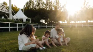 Familia disfrutando de una tarde soleada en el césped de un parque local.