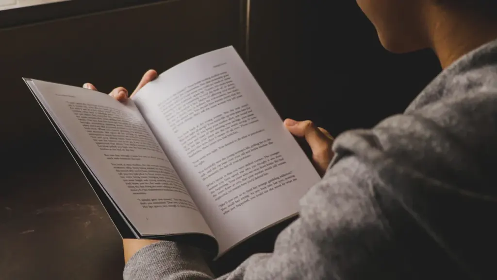 Una persona leyendo un libro de poesía en un ambiente tranquilo y cercano.
