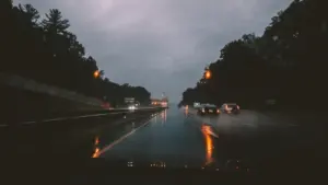 Coches circulando por una carretera mojada bajo una lluvia intensa de otoño.