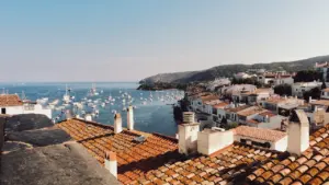 Vista panorámica de barcos en la costa brava con montañas al fondo en España.