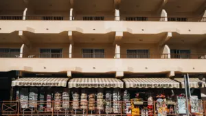 Fachada de un supermercado local en España con carteles de productos y precios visibles.
