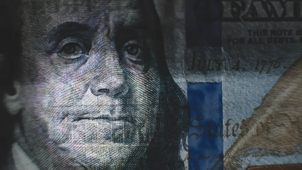 Detalle en primer plano de un billete de cien dólares estadounidenses.
