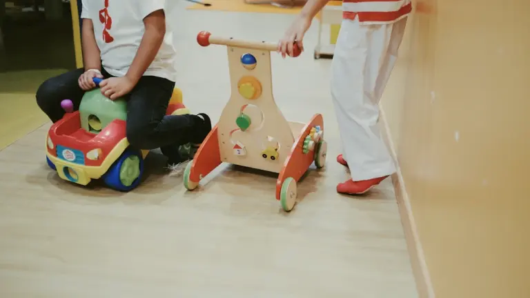 Niños jugando con juguetes de madera en un espacio de atención pediátrica.