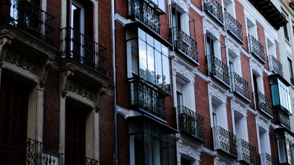 Edificios residenciales con balcones típicos en una calle urbana de Madrid.