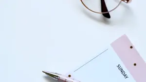Libreta de domingo con gafas y bolígrafo para organizar la semana con calma.
