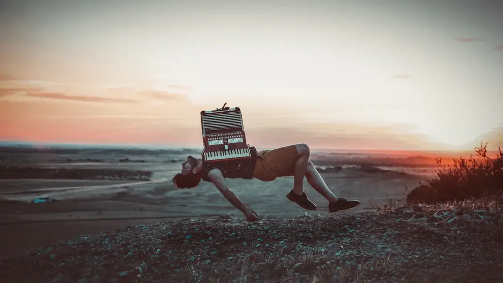Una persona levitando con un acordeón al atardecer, simbolizando libertad y un sueño onírico.