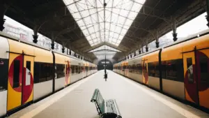 Estación de tren vacía con bancos metálicos, evocando soledad y espera silenciosa.