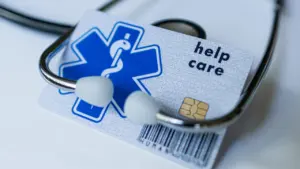 Tarjeta sanitaria europea junto a un estetoscopio para asistencia médica en viajes.