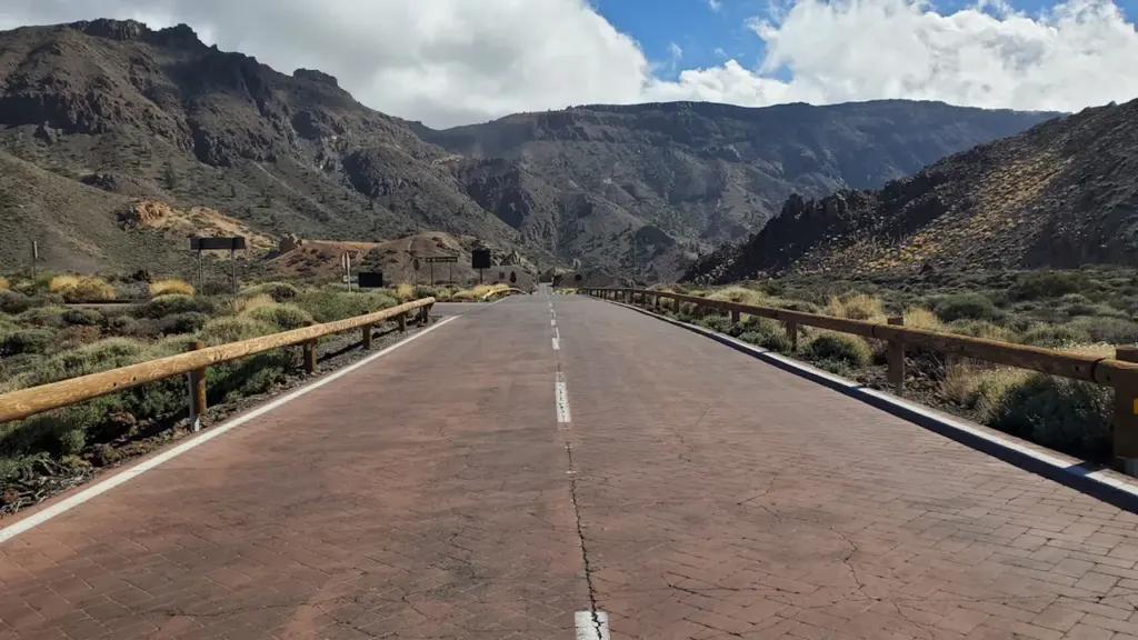 Carretera asfaltada con montañas al fondo en el Parque Nacional del Teide, España